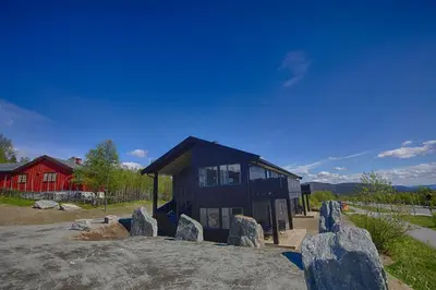 a small black house with rocks in front of it at A Family-Friendly, Pet-Friendly Getaway In Beitostølen Center in Beitostøl