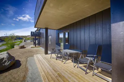 a patio with chairs and a table and a building at A Family-Friendly, Pet-Friendly Getaway In Beitostølen Center in Beitostøl