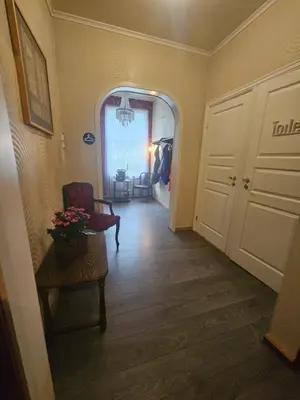 a hallway with a door and a chair and a room at Eides Hotel in Høyanger