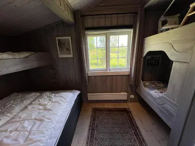 a bedroom with two bunk beds and a window at Welcoming Cabin With Fireplace & Modern Kitchen in Beitostøl