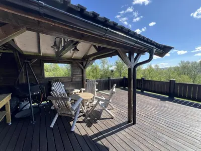 a wooden deck with a table and chairs on it at Welcoming Cabin With Fireplace & Modern Kitchen in Beitostøl