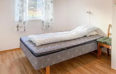 a bed sitting in a room with a window at 3 Bedroom Nice Home In Mjosundet in Ertvåg