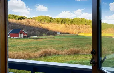 a window view of a field with a red barn at 3 Bedroom Nice Home In Mjosundet in Ertvåg