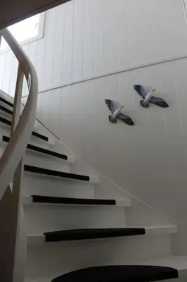 two birds on a wall next to a staircase at Oceanview House Ideal for Peaceful Holidays in Venøya
