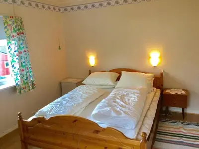 a bed with white sheets and pillows in a bedroom at Oceanview House Ideal for Peaceful Holidays in Venøya