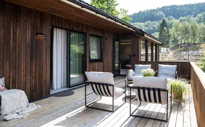 a patio with two chairs and a table on a deck at Eksklusiv Enebolig in Bergen