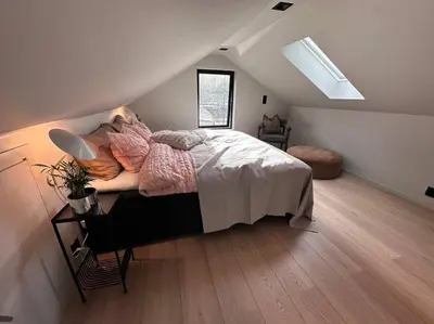a bedroom with a bed and a desk in a attic at Eksklusiv Enebolig in Bergen