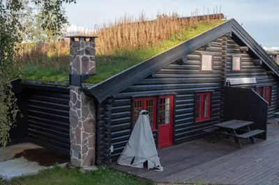 a log cabin with a red door and a chimney at Vikinggrenda 21B in Trysil