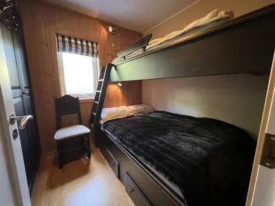 a bedroom with a bunk bed and a chair at Cozy Getaway Sauna and Terrace in Beitostøl