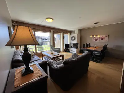 a living room with a couch and a table at Cozy Getaway Sauna and Terrace in Beitostøl