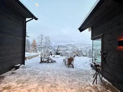 a patio with snow on the ground and people in the distance at Panorama ski inn out, jacuzzi,Badstu in Kvam