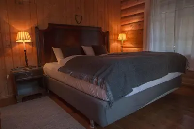a bedroom with a large bed with two lamps at Phillipshaugen Lodge in Øksendalsøra