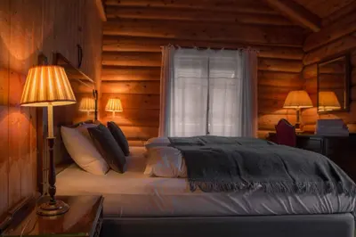 a bedroom with a bed with a window and two lamps at Phillipshaugen Lodge in Øksendalsøra