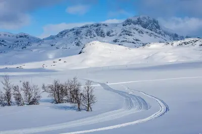 a snow covered mountain with a road in the foreground at Charming cabin Near Jotunheimen Trails in Beitostøl