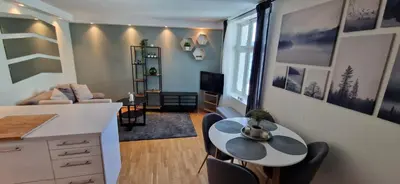 a kitchen and living room with a table and chairs at Central 1 bedroom apartment with a view in Bergen