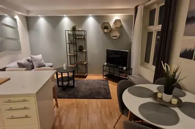 a living room with a table and a couch and a tv at Central 1 bedroom apartment with a view in Bergen
