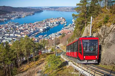 a red train on a hill overlooking a harbor at Central 1 bedroom apartment with a view in Bergen