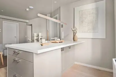 a kitchen with white cabinets and a white counter top at Stay l Nordnes in Bergen
