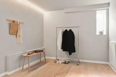 a white room with a clothes rack and a table at Stay l Nordnes in Bergen