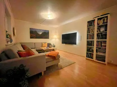 a living room with a couch and a tv at Idyllisk hus i Vassenden sentrum in Vassenden