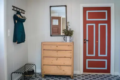 a room with a red door and a dresser and a mirror at Unikt gårdshus - Gamlestua in Vestre Gausdal