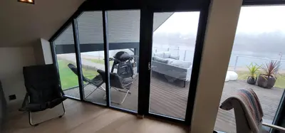 a man sitting in a chair on a balcony at Unique 3-Storey House in Trysil Luxury Living in the Heart of the Village in Trysil