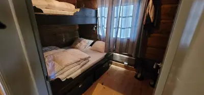 a small room with a bed and a window at The Whole Beautiful Cabin With Jacuzzi A Luxurious Getaway in Solberglia in Østby