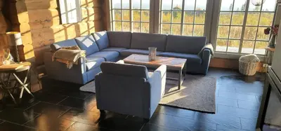 a living room with a blue couch and a table at The Whole Beautiful Cabin With Jacuzzi A Luxurious Getaway in Solberglia in Østby