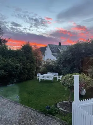 a backyard with a white fence and a white bench at Exclusive 1920 century villa 10 min from AirPort in Malvik