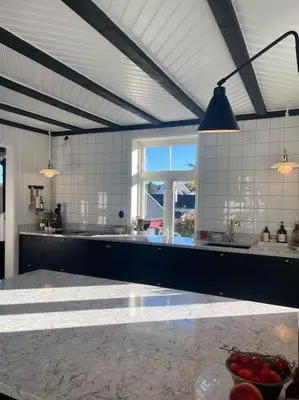a large kitchen with a table and a window at Exclusive 1920 century villa 10 min from AirPort in Malvik