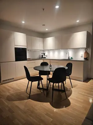 a kitchen with a table and chairs in a room at Toppleilighet på elvekanten med to romslige soverom in Førde