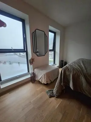 a bedroom with a bed and a large window at Toppleilighet på elvekanten med to romslige soverom in Førde