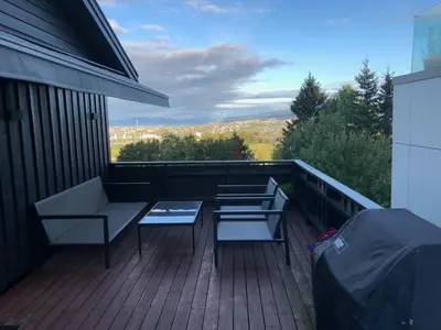a balcony with two chairs and a table on it at Sjarmerende enebolig in Trondheim