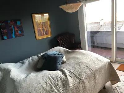 a bedroom with a bed with a blue pillow on it at Sjarmerende enebolig in Trondheim