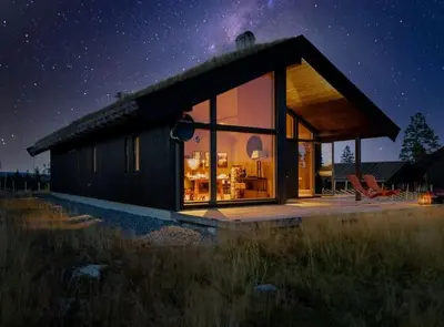 a small house with a large window at night at Modern cabin with a Mountain View in Nos