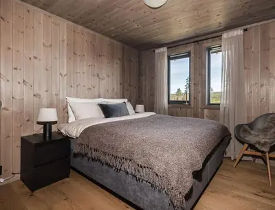 a bedroom with a large bed and a chair at Modern cabin with a Mountain View in Nos