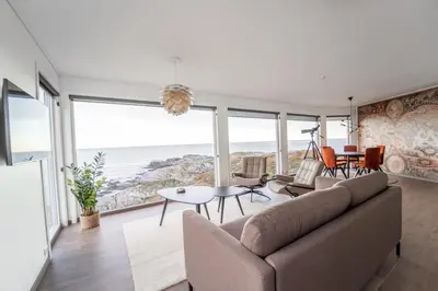 a living room with a couch and a view of the ocean at Runde Panorama - Batavia Dream in Terøy