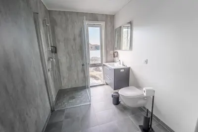 a bathroom with a shower and a toilet and a sink at Runde Panorama - Blått Hav in Terøy