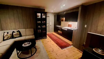 a living room with a couch and a kitchen at Stallen in Heggem