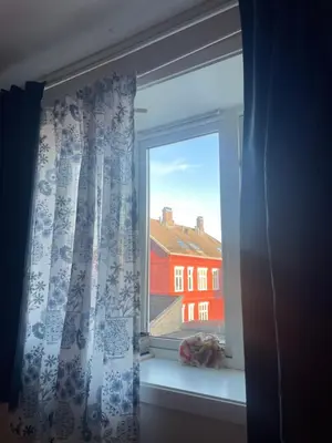 a window with a view of a red building at Cozy room near city centre in Trondheim