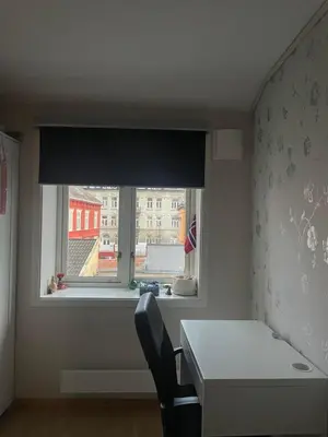 a room with a desk and a window with a table and a chair at Cozy room near city centre in Trondheim