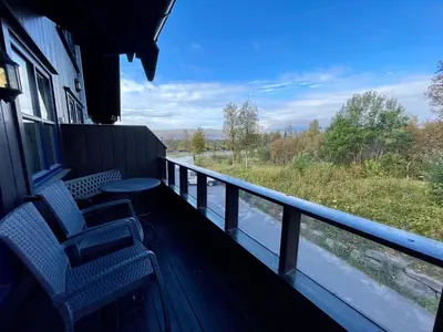 a balcony with two chairs and a view of a river at Perfect For Skiing And City Access in Beitostøl