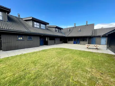 a yard with a picnic table in front of a building at Perfect For Skiing And City Access in Beitostøl