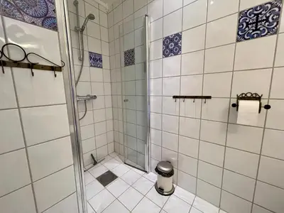 a bathroom with a shower with blue and white tiles at Perfect For Skiing And City Access in Beitostøl