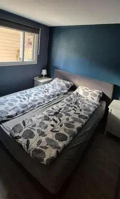 a bed in a bedroom with a blue wall at Rekkehus med 3 soverom in Trondheim