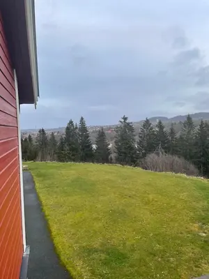 a view of a grassy field next to a house at Ski VM 2025 in Trondheim
