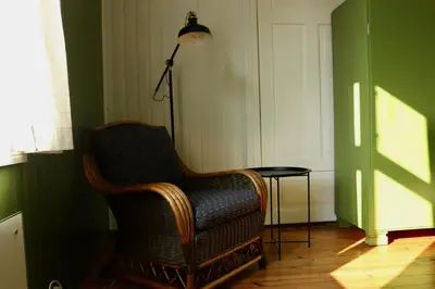 a room with a chair and a lamp and a table at Sjarmerende hus i sentrum in Elverum