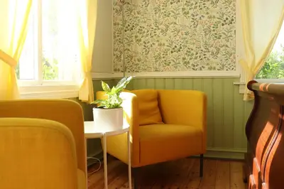 a living room with a yellow chair and a table at Sjarmerende hus i sentrum in Elverum