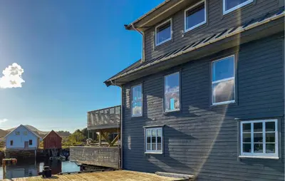 a house with a deck next to a body of water at Beautiful Home In Fjørtoft With Wifi in Fjørtoft
