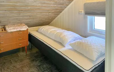 a bed in a room with a dresser and a window at Beautiful Home In Fjørtoft With Wifi in Fjørtoft